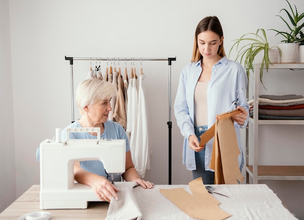 Vista frontale del sarto femminile che prepara tessuto per indumenti