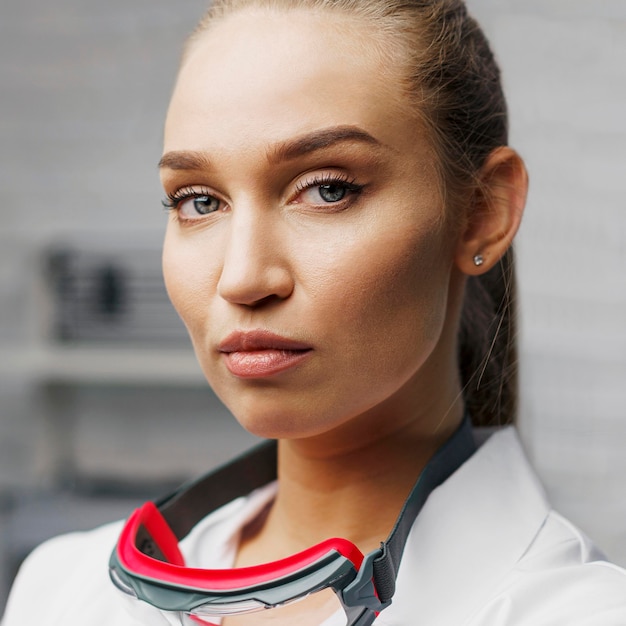 Vista frontale del tecnico femminile in posa con occhiali di sicurezza