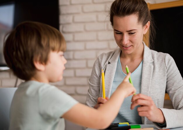 Vista frontale del tutor che insegna al bambino a contare