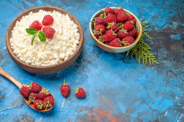 Vista frontale deliziosa ricotta con lamponi freschi su sfondo blu colore di bacche foto colazione frutta