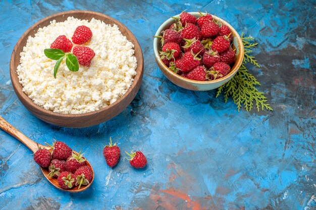 Vista frontale deliziosa ricotta con lamponi freschi su sfondo blu colore di bacche foto colazione frutta