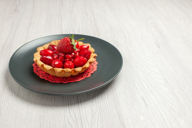 Vista frontale deliziosa torta con frutta fresca su scrivania bianca torta dessert frutta rossa
