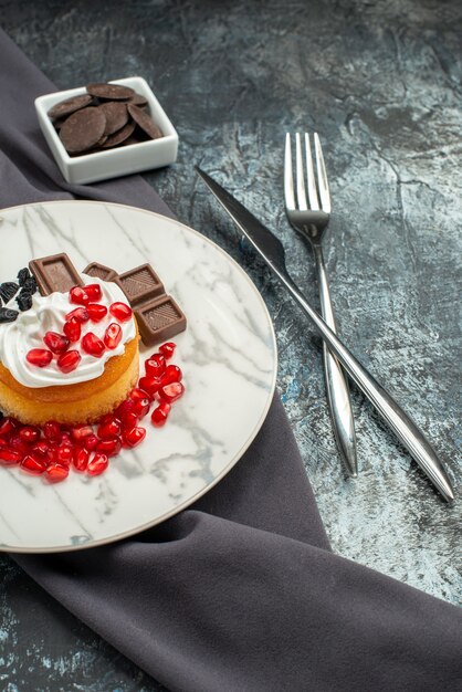 Vista frontale deliziosa torta cremosa con cioccolato e uvetta su uno sfondo chiaro-scuro biscotto dolce biscotto dolce zucchero
