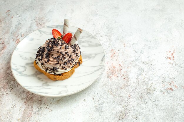 Vista frontale deliziosa torta cremosa con fragole su torta di compleanno di biscotto al tè con crema di superficie bianca dolce