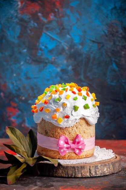 Vista frontale deliziosa torta di pasqua con crema bianca e frutta secca su sfondo scuro primavera dessert colorato torta dolce cuocere ornato
