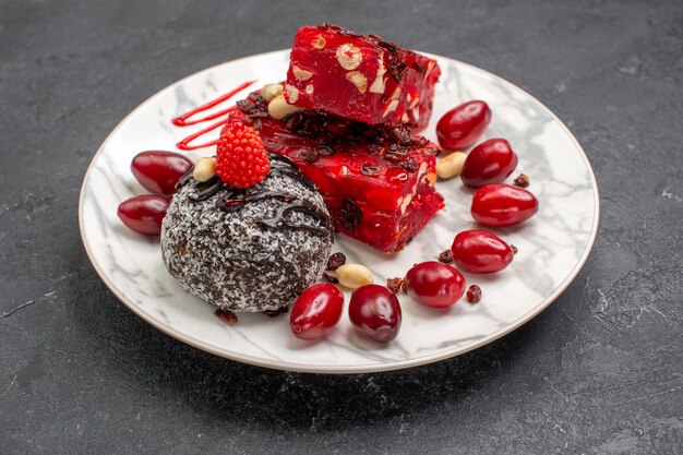 Vista frontale deliziosa torta fette torta fruttata con torta al cioccolato su uno spazio grigio