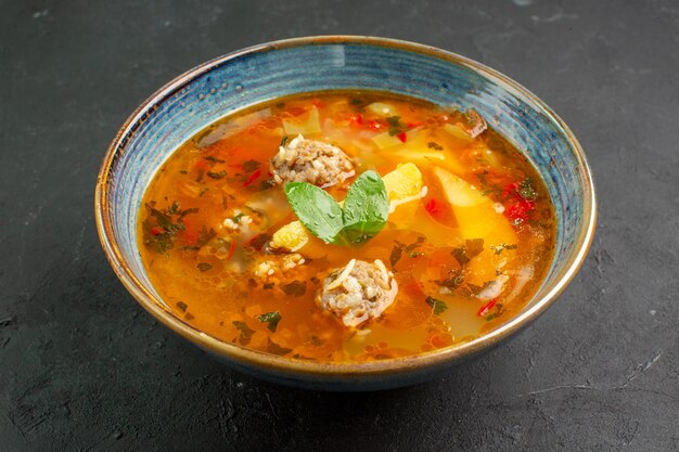 Vista frontale deliziosa zuppa con polpette di carne e patate su sfondo scuro