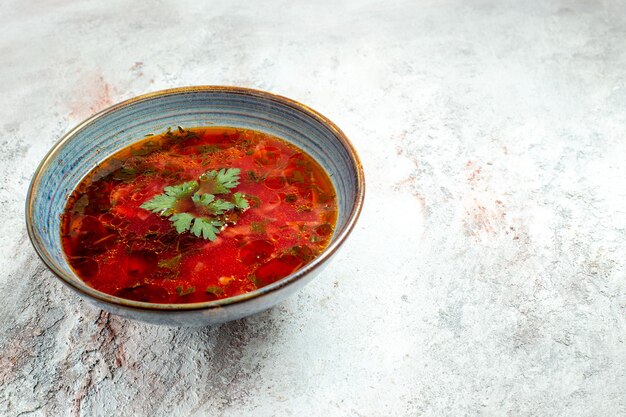 Vista frontale deliziosa zuppa di barbabietola ucraina famosa borsch con carne all'interno del piatto su spazio bianco