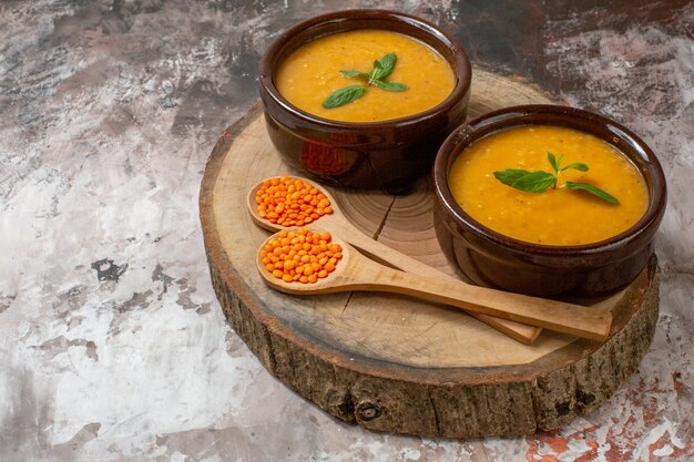 Vista frontale deliziosa zuppa di lenticchie all'interno dei piatti