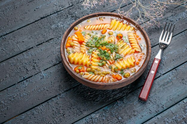 Vista frontale deliziosa zuppa di pasta da pasta italiana a spirale con verdure su piatto da pranzo rustico scuro da scrivania salsa di zuppa di pasta italiana