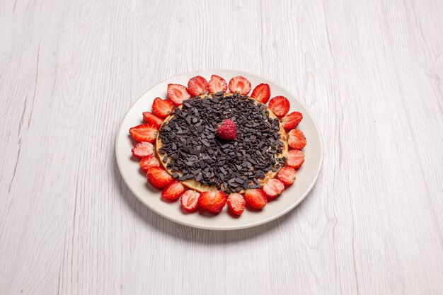 Vista frontale deliziose frittelle con fragole e scaglie di cioccolato su una scrivania bianca dolce al forno torta biscotto frutti di bosco