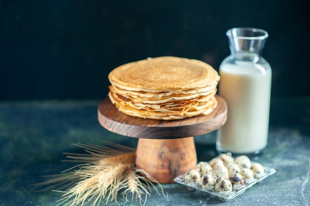 Vista frontale deliziose frittelle sulla scrivania in legno e torta dolce da colazione scura torta dolce latte miele mattina