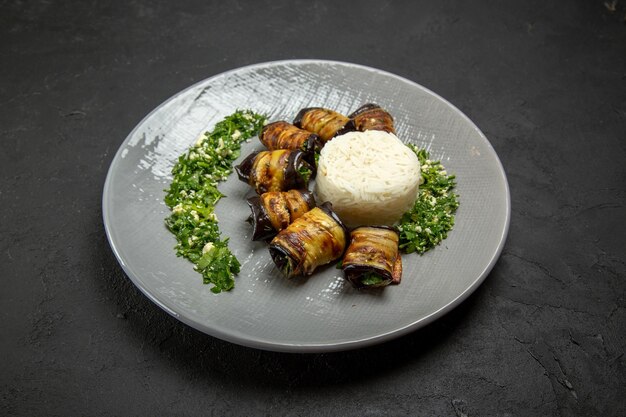 Vista frontale deliziose melanzane cotte con verdure e riso su superficie scura cena cibo olio da cucina farina di riso