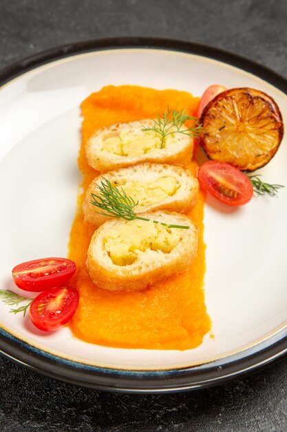 Vista frontale deliziose torte di patate con zucca all'interno del piatto sullo sfondo grigio scuro forno cuocere la fetta della cena del piatto di colore