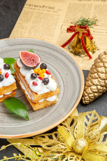 Vista frontale deliziose torte di waffle con frutta su uno sfondo grigio dolce crema di torta dessert
