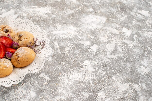 Vista frontale deliziosi biscotti di sabbia con fragole fresche su uno spazio bianco