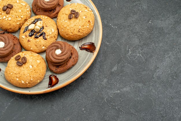 Vista frontale deliziosi biscotti dolci deliziosi dolci per il tè su uno spazio grigio