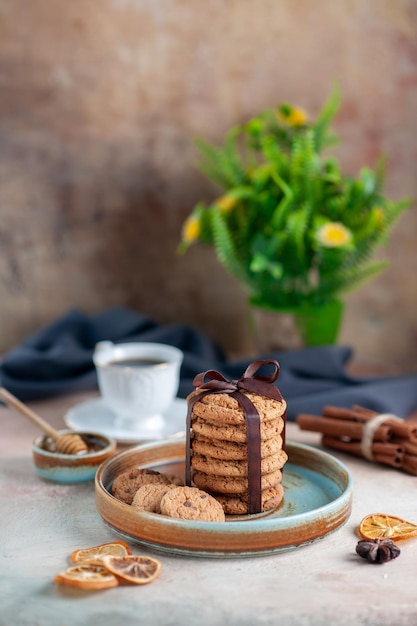 Vista frontale deliziosi biscotti dolci legati con fiocco su superficie leggera dessert dolce zucchero biscotto torte tè pasta orizzontale