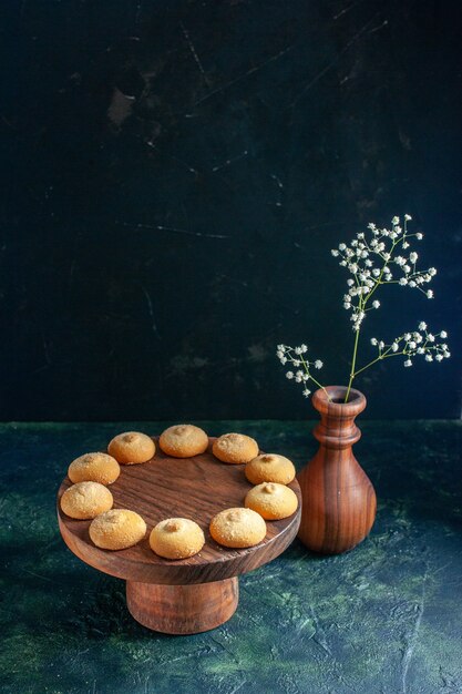 Vista frontale deliziosi biscotti dolci su biscotto blu scuro torta di zucchero torta tè foto dessert