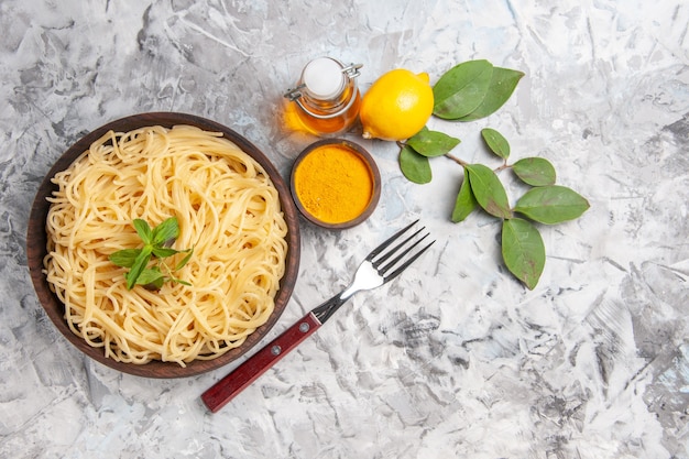 Vista frontale deliziosi spaghetti su tavola bianca pasta pasta limone