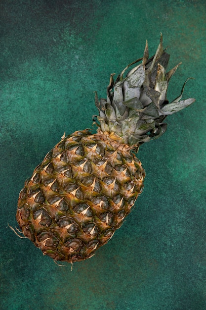 Vista frontale dell'ananas sulla superficie verde