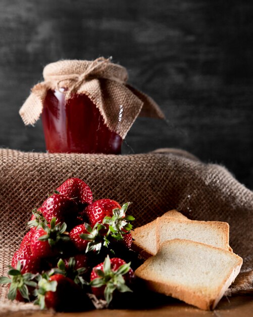 Vista frontale dell'ostruzione di fragola in barattolo con pane