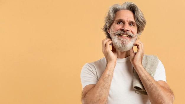 Vista frontale dell'uomo anziano con barba e asciugamano