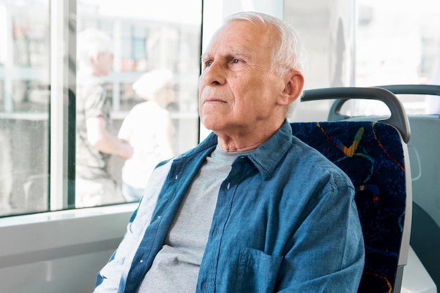 Vista frontale dell'uomo anziano nel trasporto pubblico