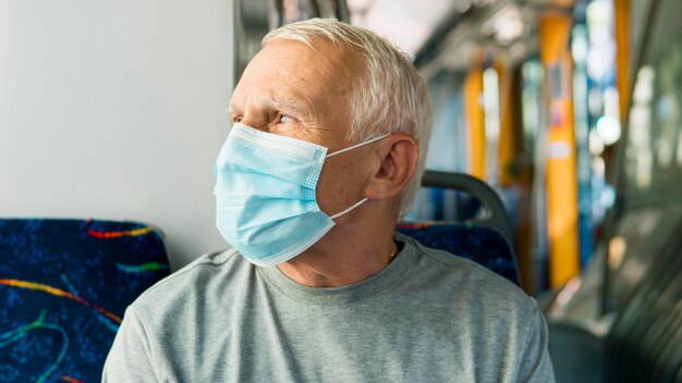 Vista frontale dell'uomo anziano nel trasporto pubblico