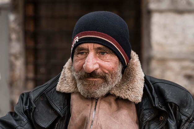Vista frontale dell'uomo barbuto senzatetto all'aperto