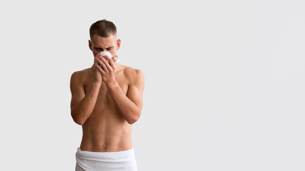 Vista frontale dell'uomo che beve il caffè al mattino con lo spazio della copia