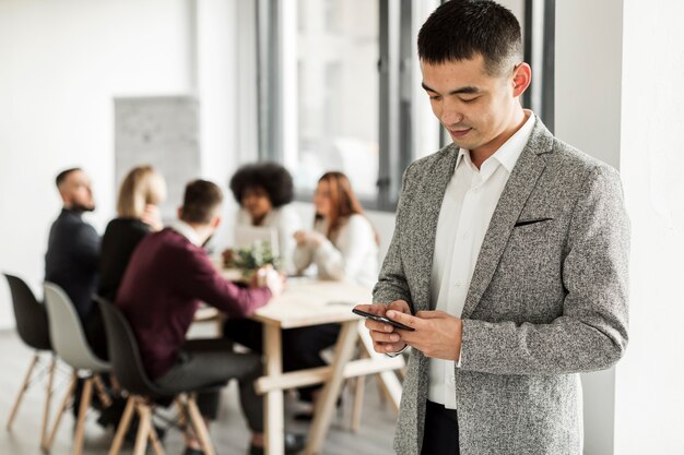 Vista frontale dell'uomo che esamina il suo telefono