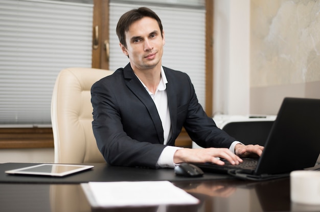 Vista frontale dell'uomo che lavora al computer portatile