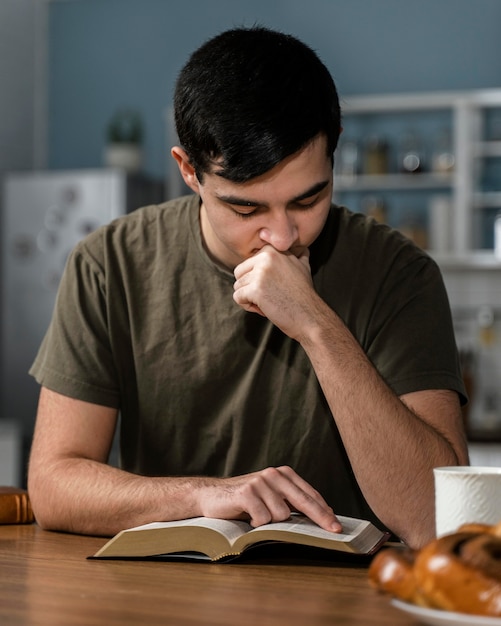 Vista frontale dell'uomo che legge dalla Bibbia