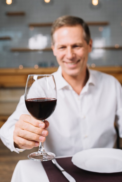 Vista frontale dell'uomo che tiene bicchiere di vino