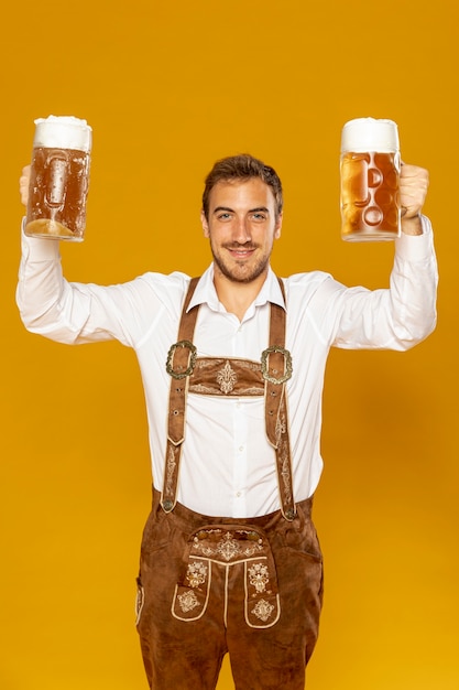 Vista frontale dell'uomo che tiene le pinte di birra