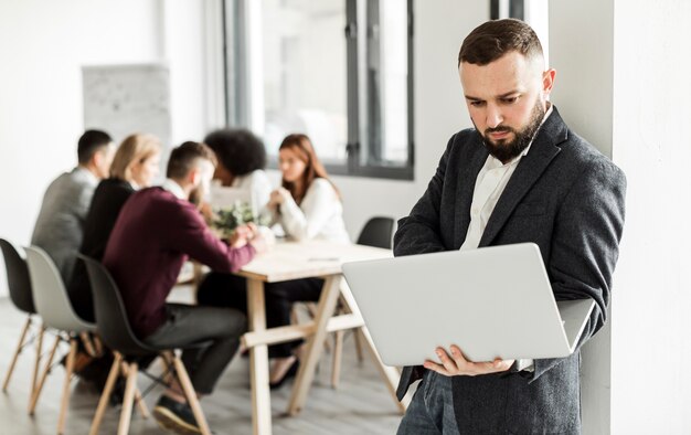 Vista frontale dell'uomo che tiene un computer portatile