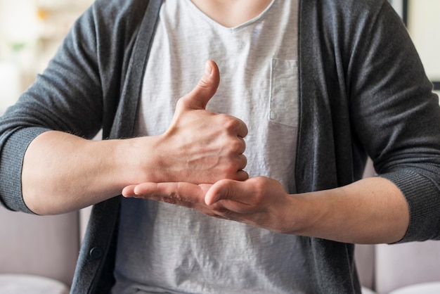 Vista frontale dell'uomo che usando il linguaggio dei segni