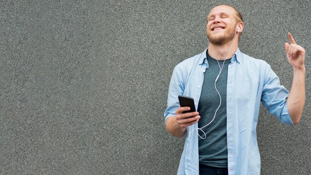 Vista frontale dell'uomo di smiley che ascolta la musica