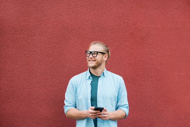 Vista frontale dell'uomo di smiley con lo smartphone