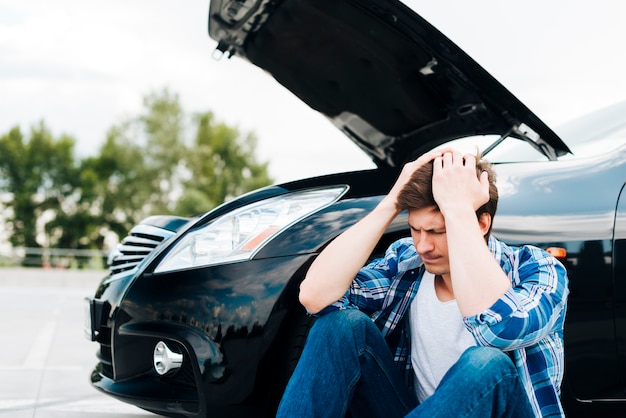 Vista frontale dell'uomo e auto nera