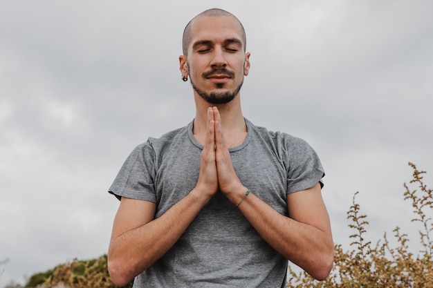 Vista frontale dell'uomo fuori che fa yoga