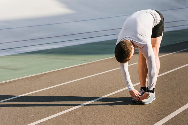 Vista frontale dell'uomo sportivo che fa allungamenti