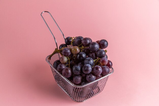 Vista frontale dell'uva acida fresca all'interno della friggitrice sulla parete rosa