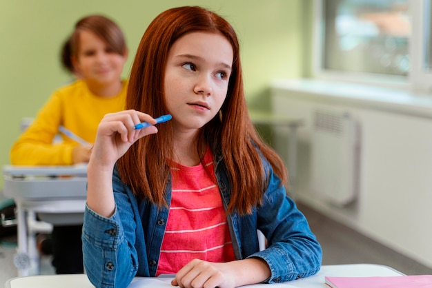 Vista frontale della bambina in classe a scuola