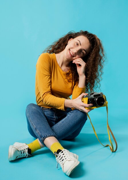 Vista frontale della bella donna con la macchina fotografica