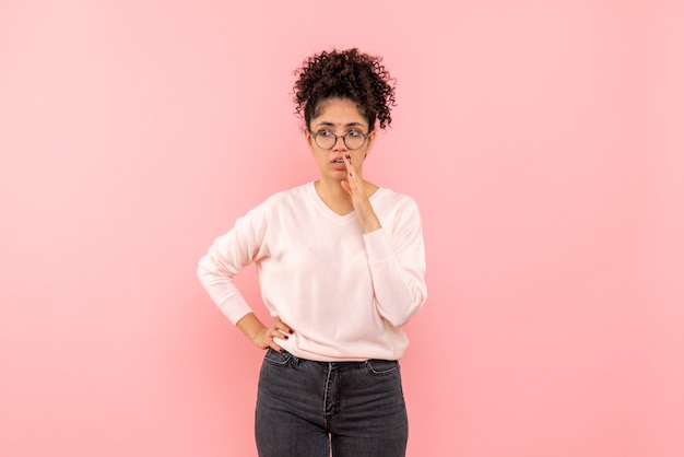 Vista frontale della bella donna confusa sul rosa