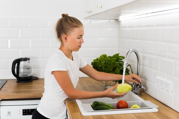 Vista frontale della bella ragazza che cucina