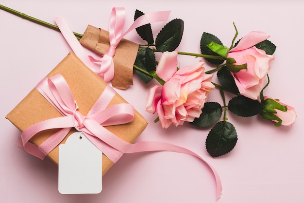 Vista frontale della confezione regalo con bouquet di rose e nastro