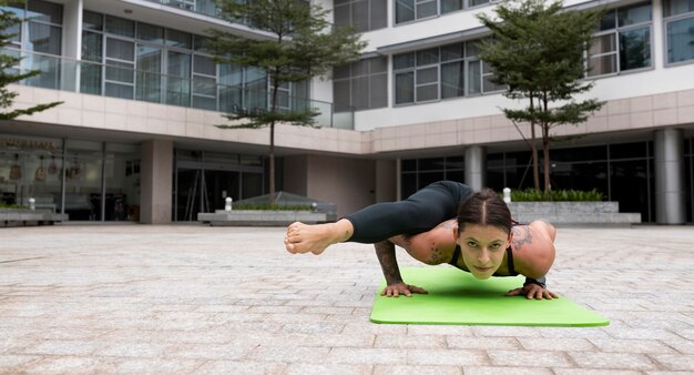 Vista frontale della donna a praticare yoga sulla stuoia